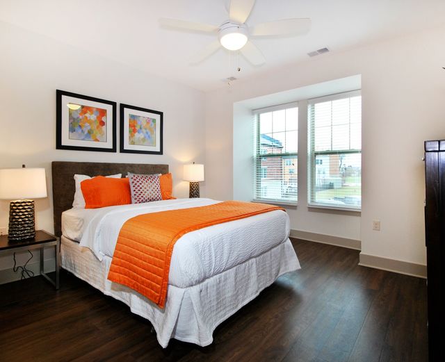 Orleans Landing - Master bedroom with dark wood paneling, large windows, and ceilings fan